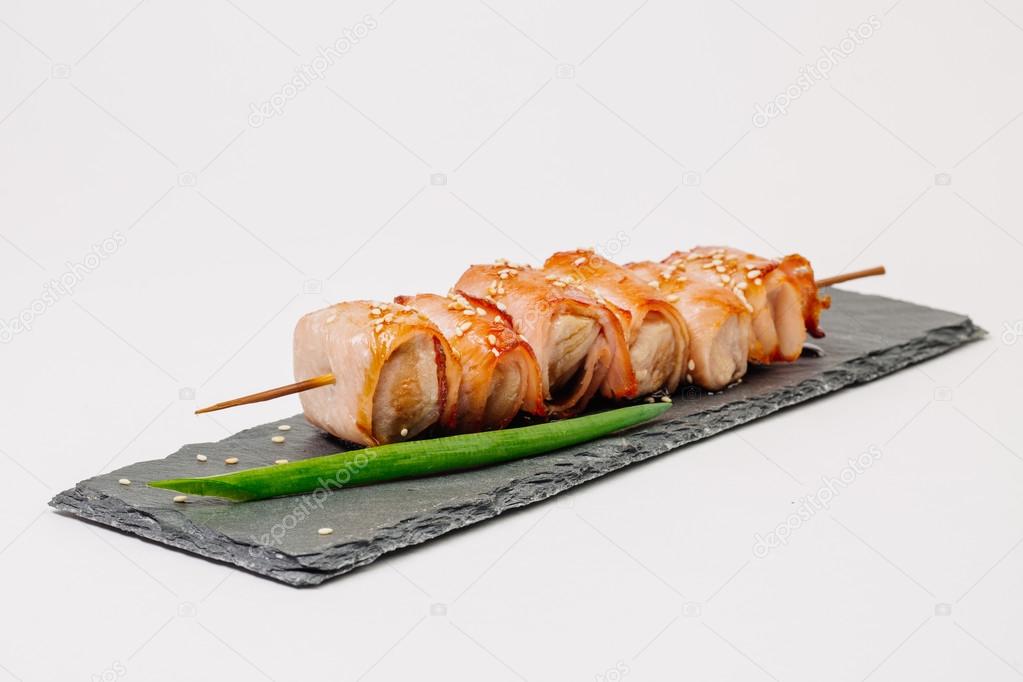 grill meat on a wooden skewer with green onions on a white backgrond