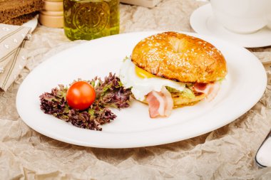 Tablo üzerinde beyaz bir tabak içinde Burger