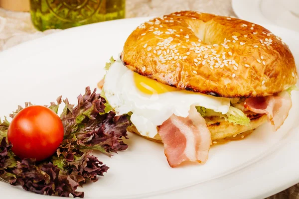 Tablo üzerinde beyaz bir tabak içinde Burger