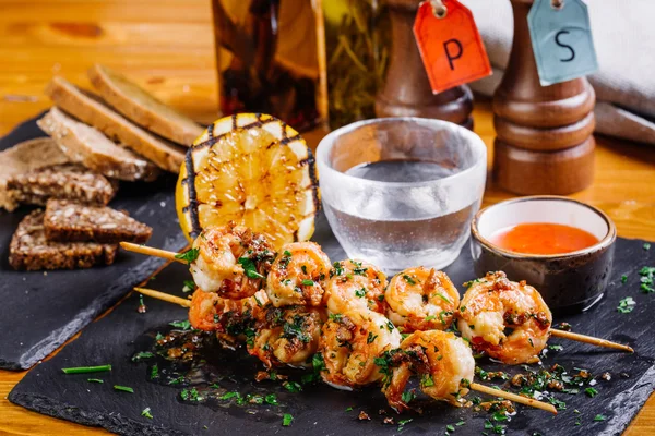 Roasted shrimps on skewers with sauce and lemon — Stock Photo, Image