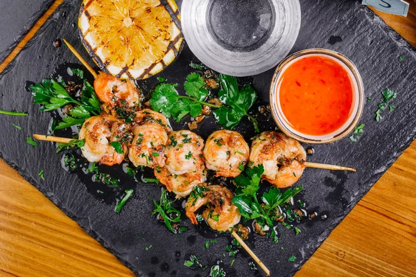 Roasted shrimps on skewers with sauce and lemon — Stock Photo, Image