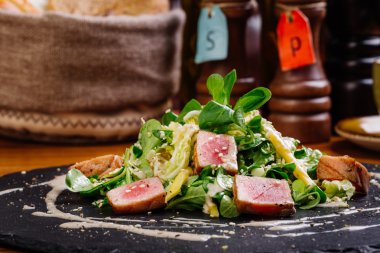 Kurutulmuş tuna susam plaka üzerinde yeşil salata ile kaplı