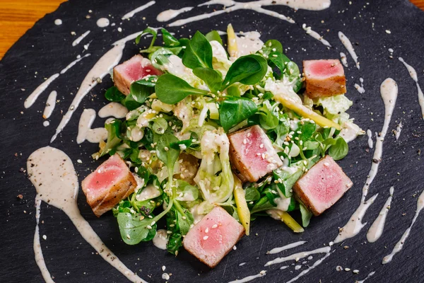 Seared tuna coated sesame seeds with green salad on plate — Stock Photo, Image