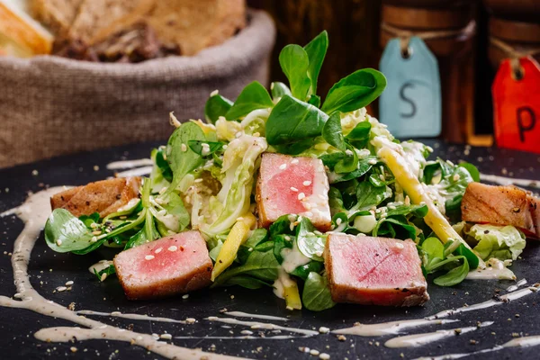 Жареные семена кунжута с тунцом с зеленым салатом на тарелке — стоковое фото