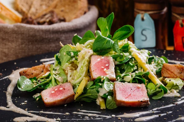 Жареные семена кунжута с тунцом с зеленым салатом на тарелке — стоковое фото