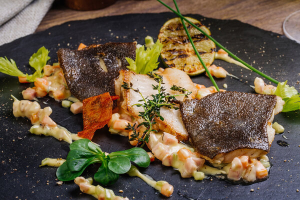 baked plaice  fillet with vegetables and sauce close-up