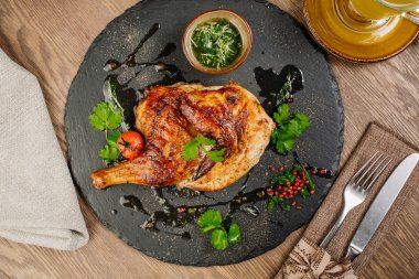 Tabaka taş plaka üzerinde soslu tavuk. 