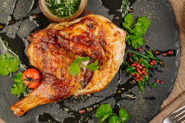 Tabaka taş plaka üzerinde soslu tavuk. 