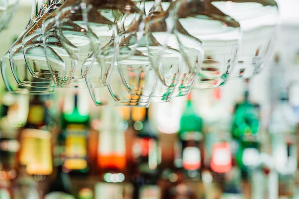 Wine glasses hanging from metal beams on defocused background. — Stock Photo, Image