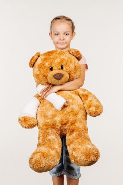 Kırık kol ile genç ciddi kız kameraya bakıyor