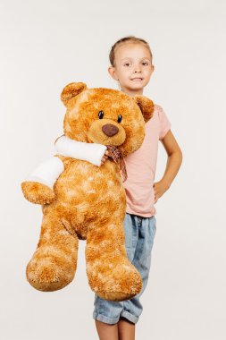 Kırık kol ile genç gülümseyen kız kameraya bakıyor