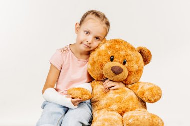 Kırık kol ile genç kız kameraya bakıyor