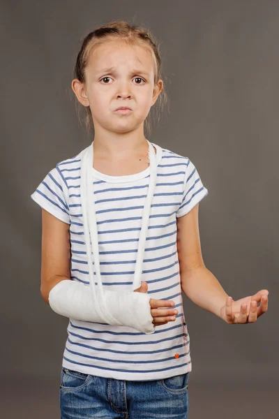 Jeune fille triste et ennuyée avec le bras cassé est debout sur le gr — Photo