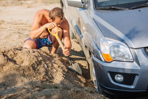 Jonge Man Uitgraven Zand Verwijderen Uit Auto — Stockfoto