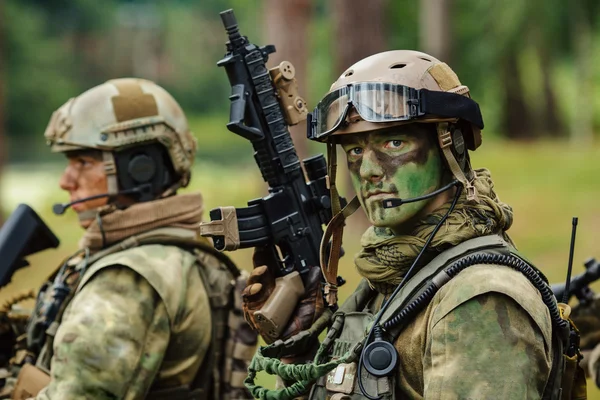 Soldado fica com armas e olha para a frente — Fotografia de Stock