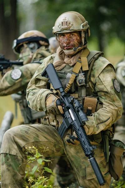 Soldat steht mit Waffen und blickt nach vorn — Stockfoto