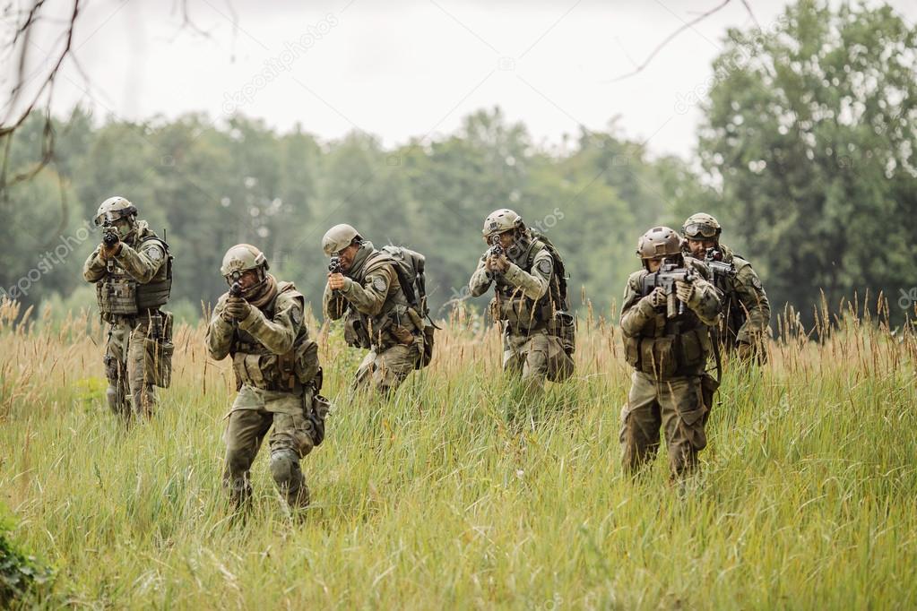 Group of soldiers running across the field and shoot