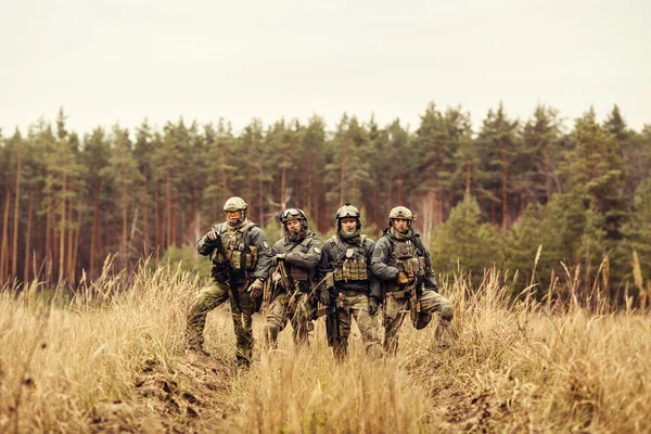 Skupina vojáků stojí s rukama a při pohledu na fotoaparát — Stock fotografie
