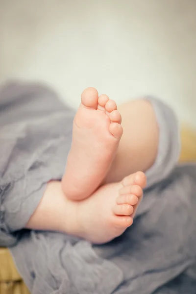 Baby feet out of the end of the sheets — Stock Photo, Image