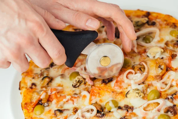 Pizza siendo cortada por el cortador — Foto de Stock