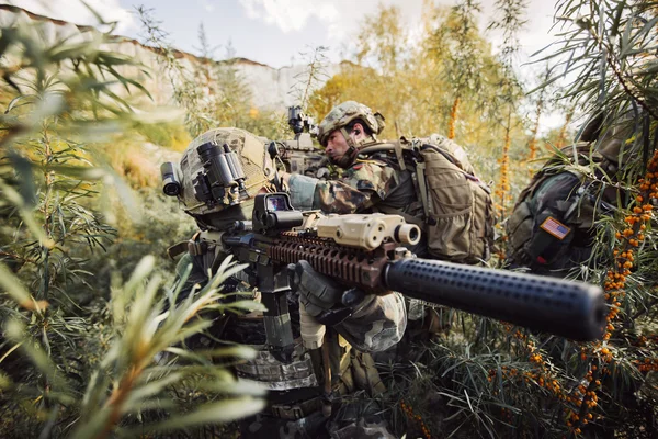 Equipo de soldados con armas observando el territorio — Foto de Stock