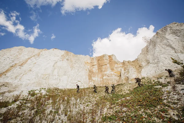 Soldati in squadra sulla collina con una guida — Foto Stock