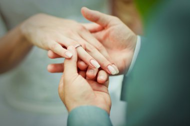 bir nişan yüzüğü yerleştirerek damat