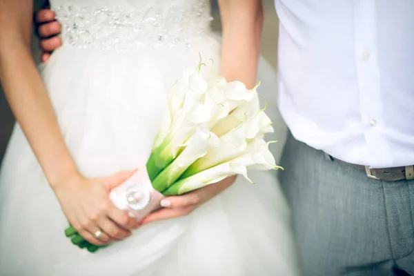 Ramo de hermosas flores blancas en las manos de la novia — Foto de Stock