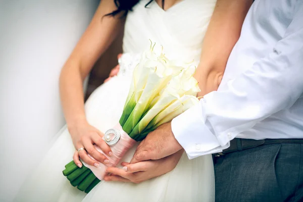 Mazzo di bei fiori bianchi nelle mani della sposa e — Foto Stock