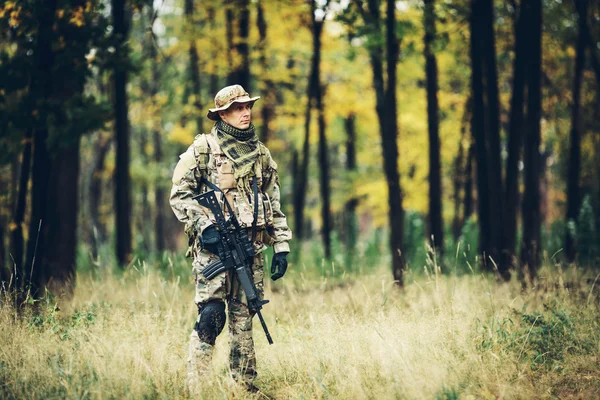 Soldat med gevær i skogen. – stockfoto