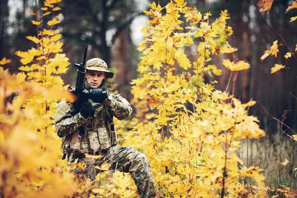 Soldat med gevær i skogen. – stockfoto