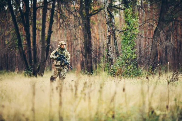 Soldaat met geweer in het bos — Stockfoto