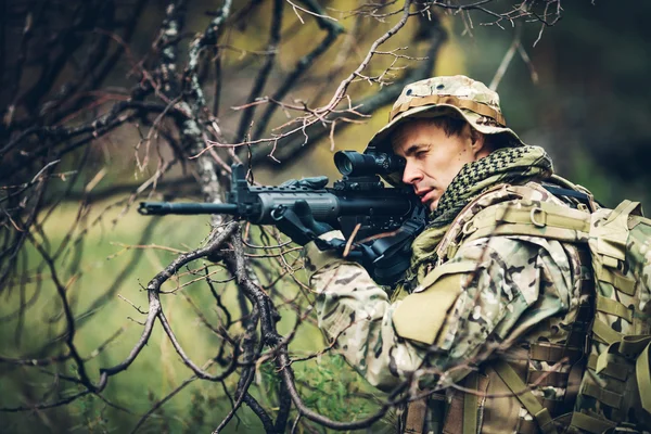Żołnierz z karabinem w lesie — Zdjęcie stockowe