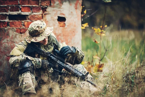 Voják s puškou v lese — Stock fotografie