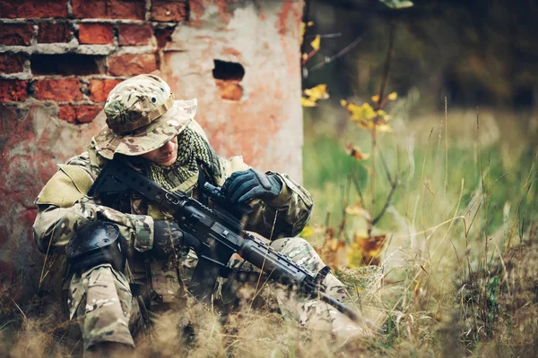 Soldat med gevær i skogen. – stockfoto