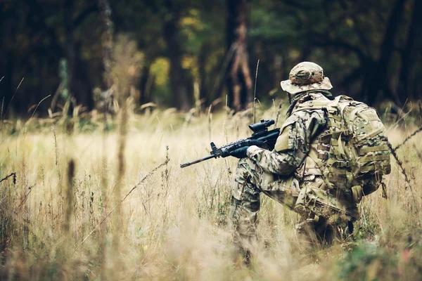 Soldat avec fusil dans la forêt — Photo