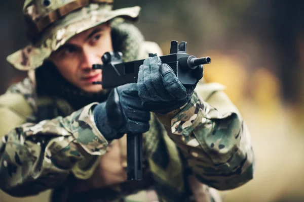 Soldat med gevær i skogen. – stockfoto