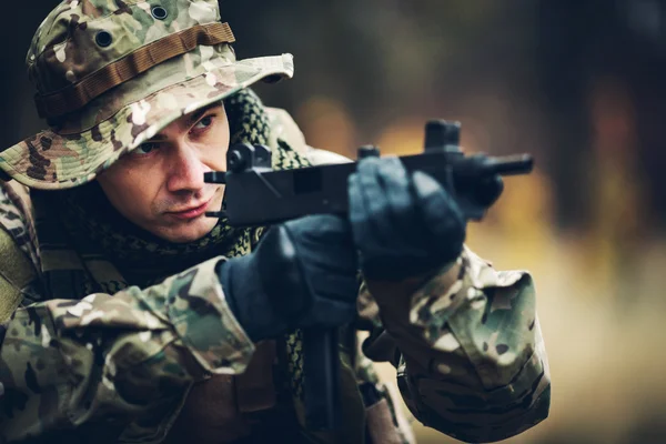 Soldado con rifle en el bosque — Foto de Stock