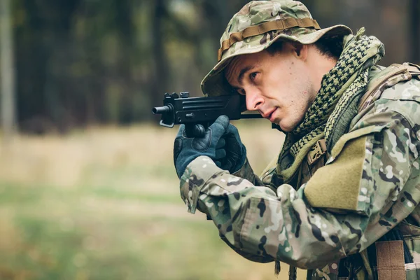 Soldado com espingarda na floresta — Fotografia de Stock