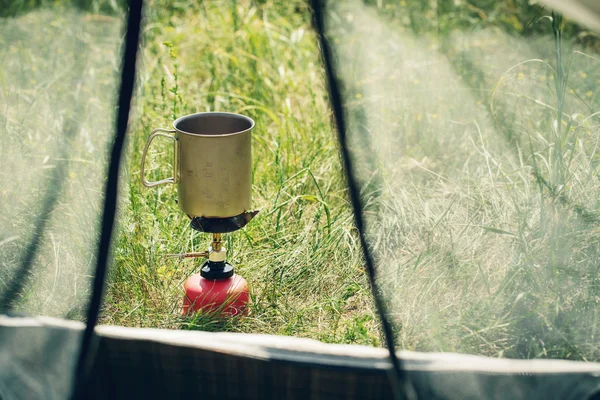 Acqua bollente in tazza su stufa da campeggio portatile — Foto Stock