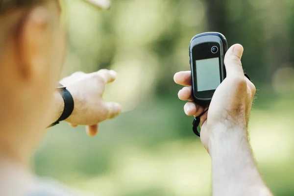 Man houdt een GPS-ontvanger en plan in zijn hand. — Stockfoto