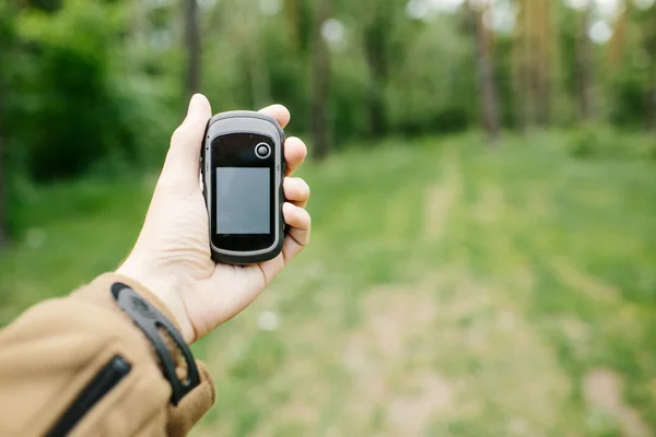 GPS 수신기를 들고 있는 남자와 그의 손에 계획. — 스톡 사진