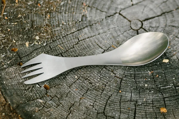 Spork lying on a wooden stump in the forest — Stockfoto