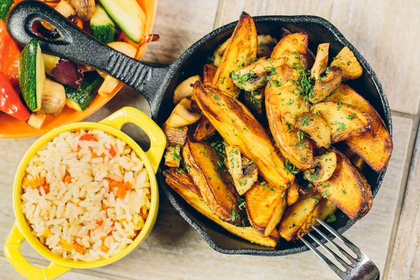 Una padella di patate al forno con una ciotola di riso e verdure — Foto Stock