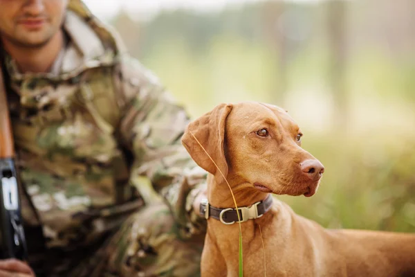 Jägare med en hund på skogen — Stockfoto