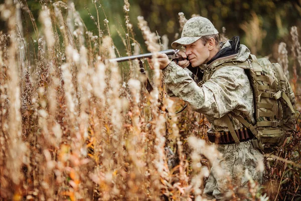 Homem caçador com espingarda na floresta — Fotografia de Stock