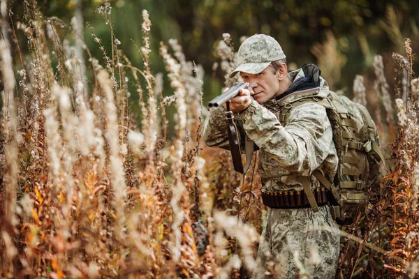Man hunter with shotgun in forest — Stock Photo, Image