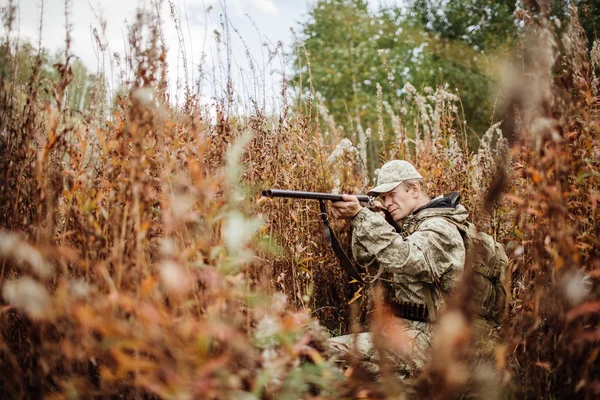 Άνδρα κυνηγό με κυνηγετικό όπλο στο δάσος — Φωτογραφία Αρχείου