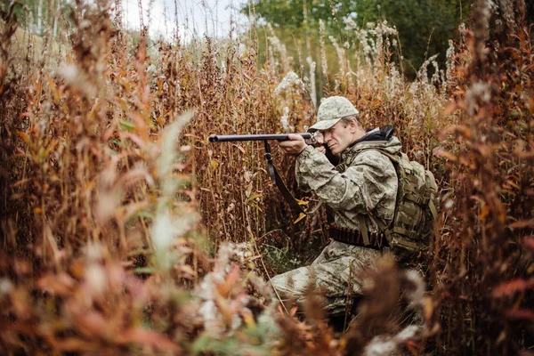 Insan avcısı ormanda av tüfeğiyle — Stok fotoğraf