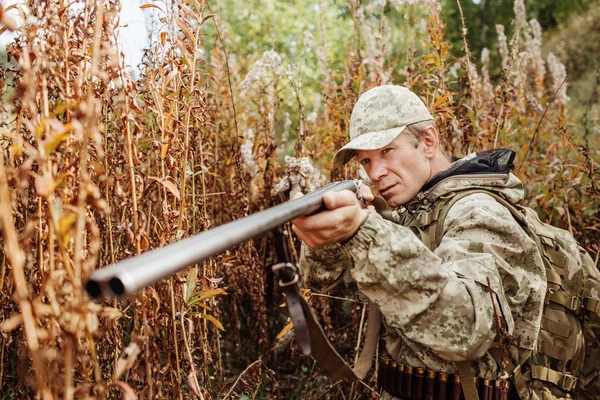 Man jägare med hagelgevär i skogen — Stockfoto